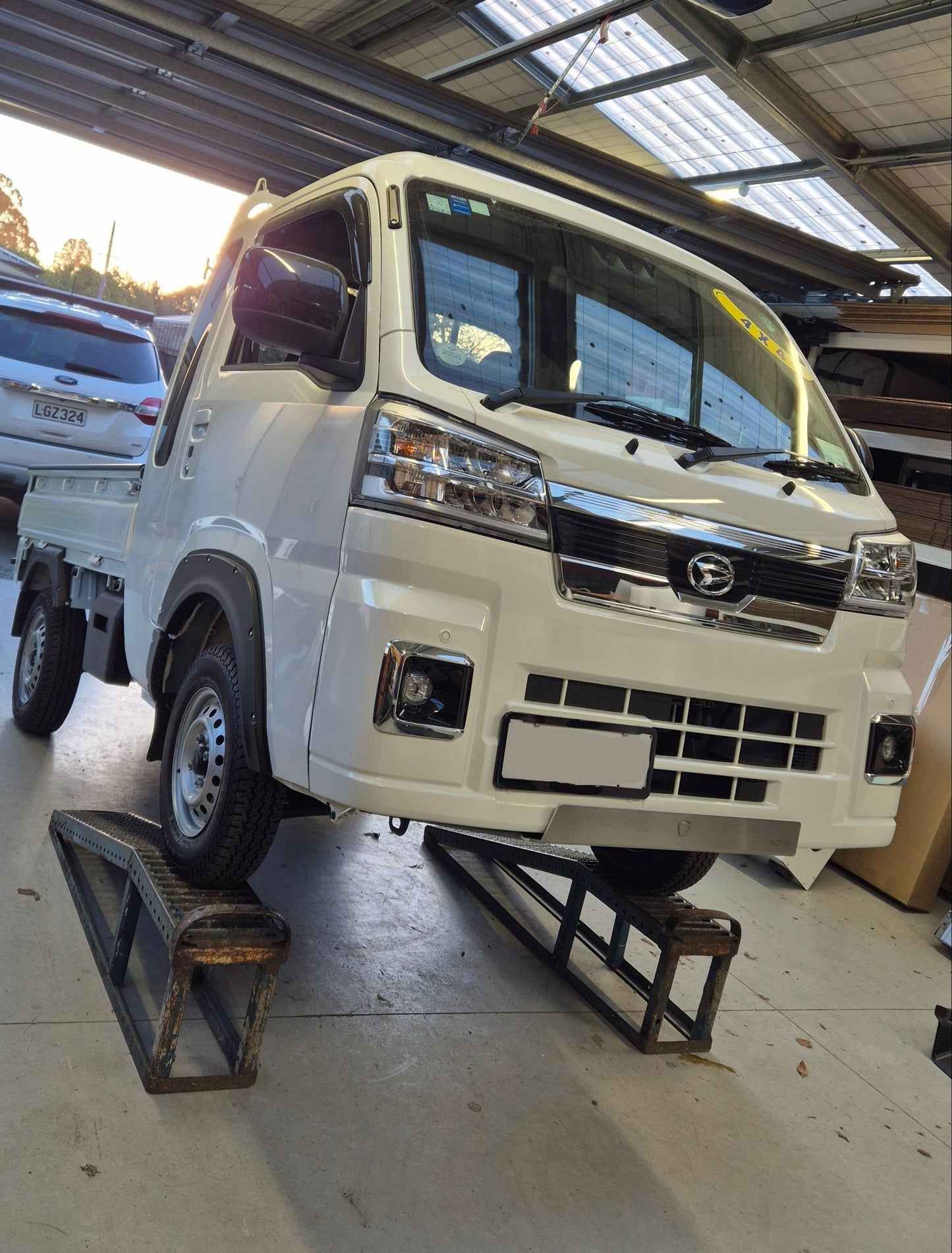 White truck with 'Daihatsu' branding inside a building